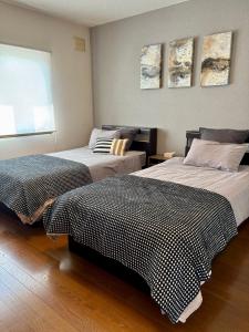 two beds sitting next to each other in a room at Olive retreat Sapporo 札幌市南区 一軒家の1フロア貸切 5名まで 2ベッドルーム 無料駐車場 登山 スキー場への好アクセス in Sapporo