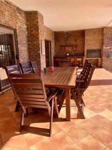 a wooden table and chairs in a room at Emmanuel Guest Villa in Thabazimbi