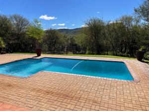 a small swimming pool on a brick patio at Emmanuel Guest Villa in Thabazimbi