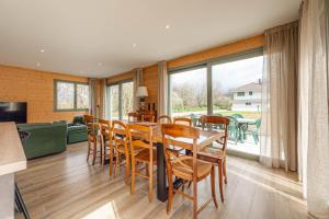 a dining room with a table and chairs and a large window at Villa Mareyland Saint-Jorioz, in Saint-Jorioz