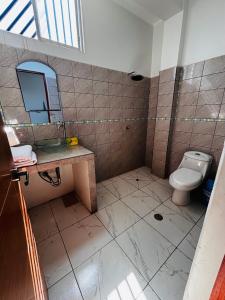 a bathroom with a toilet and a sink and a mirror at Flat pucallpa in Pucallpa