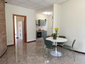 a room with a table and chairs and a kitchen at Home among the olive trees in Tivoli