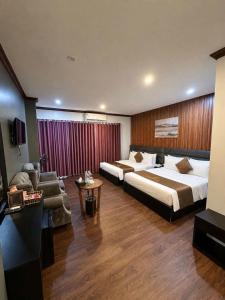 a hotel room with two beds and a couch at Hotel Red River in Hà Ðông