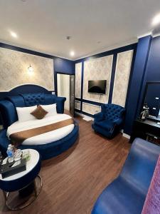 a bedroom with a large bed and a blue wall at Hotel Red River in Hà Ðông