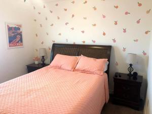 a bedroom with a bed with pink sheets and butterflies on the wall at The Beach Peach in Port Aransas