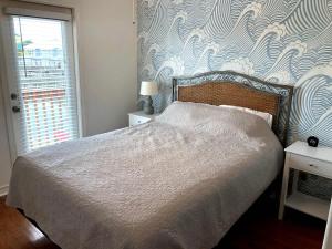 a bedroom with a bed with a blue and white wallpaper at The Beach Peach in Port Aransas +9 photos