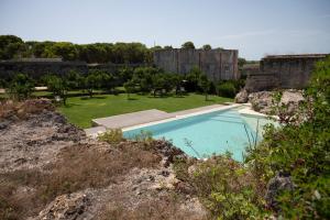 a large swimming pool in a yard with a field at Masseria Galeasi in Grottaglie