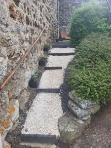 a stone walkway next to a stone wall at Maison d´hôtes La Dromandise in Saint-Arcons-de-Barges +10 photos