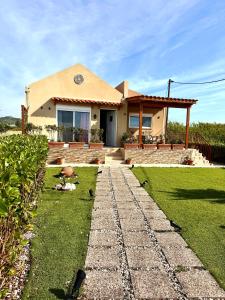 a house with a stone walkway in front of it at Blue Waves House 2 in Soroni