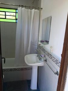 a bathroom with a sink and a shower and a mirror at Casita Naranja in La Calera