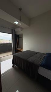 a bedroom with a bed and a large window at Izze Home in Palmas