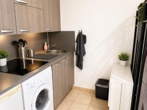 a kitchen with a washer and a sink and a washing machine at Dramont Getaway in Saint-Raphaël