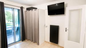 a room with a flat screen tv on a wall at Dramont Getaway in Saint-Raphaël