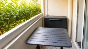 a black bench sitting on a balcony with a window at Dramont Getaway in Saint-Raphaël