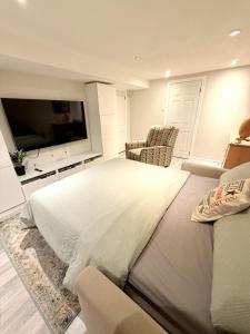 a bedroom with a large bed and a flat screen tv at Large Private Suit With Free Parking in Mississauga