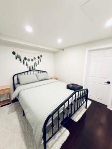 a bedroom with a large bed with white sheets at Large Private Suit With Free Parking in Mississauga
