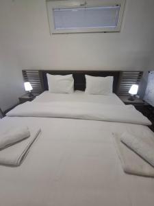 a bedroom with a large white bed with two pillows at Airport apartment Delić in Golubovci
