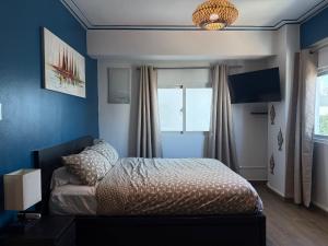 a bedroom with a bed with blue walls and a window at City Oasis in Santo Domingo +19 photos