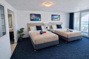 a hotel room with two beds and a balcony at Relaxing Ocean View Condo by the Beach in San Juan