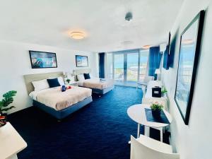 a hotel room with two beds and a table at Relaxing Ocean View Condo by the Beach in San Juan +13 photos