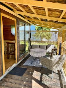 a patio with a couch and a table on a deck at House by the river in Ptuj