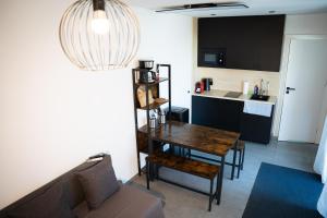 a living room with a table and a kitchen at Black Wood Tiny House in Mendig - Eifel Escape in Mendig