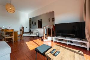 a living room with a large flat screen tv at Sailor House - By Wehost in Porto Santo