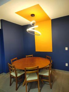 a dining room with a wooden table and blue walls at Izze Home in Palmas +83 photos