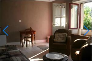 a living room with a couch and a chair and a table at Chambre d'hôtes beau rivage in Falletans