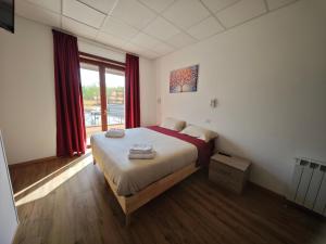 ein Schlafzimmer mit einem Bett und einem großen Fenster in der Unterkunft Bed&Harmony in Colleferro