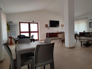 a dining room and living room with a table and chairs at Agriturismoteo in Bernalda