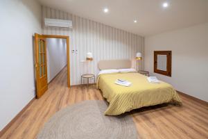 a bedroom with a large bed with a yellow blanket at Ca L'Avi in Ca l’Avi