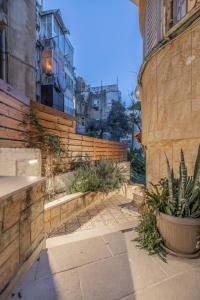 a courtyard with a retaining wall and a plant at Masada34a City Center in Haifa