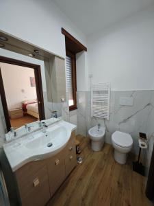 ein Badezimmer mit Waschbecken, Toilette und Spiegel in der Unterkunft Bed&Harmony in Colleferro