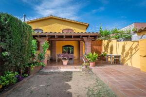 a yellow house with a patio and a fence at Ca L'Avi in Ca l’Avi