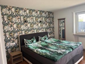 a bedroom with a bed with a flowery wallpaper at Appartementhaus Silke in Bad Füssing