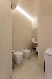 a white bathroom with a toilet and a bidet at Civico Dodici in Modica