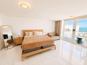 a large bedroom with a bed and a mirror at Oceanview Beach Condo in Prime Location in San Juan