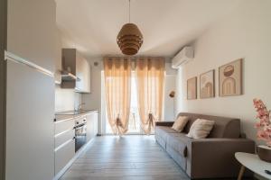 a living room with a couch and a kitchen at Casa a due passi dal mare in Alba Adriatica
