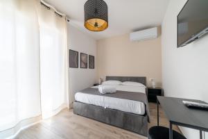 a bedroom with a bed and a desk and a television at Casa a due passi dal mare in Alba Adriatica