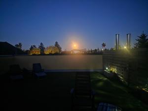 a night view of a patio with chairs on a wall at Hawa's Penthouse Studio with Terrace in Eferding +57 photos