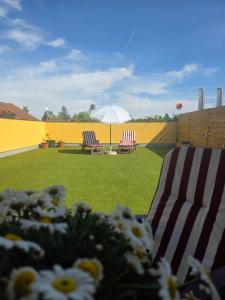 two lawn chairs and an umbrella in a yard at Hawa's Penthouse Studio with Terrace in Eferding