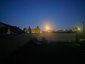 two chairs sitting on a patio at night at Hawa's Penthouse Studio with Terrace in Eferding
