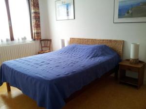 a bed in a bedroom with a blue bedspread at Apartment mit Gemeinschaftspool im Diois by Interhome in Die