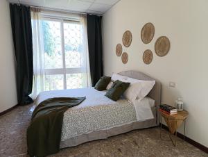 a bedroom with a bed with pillows and a window at Home among the olive trees in Tivoli