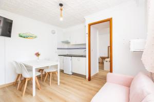 a kitchen and dining room with a white table and chairs at Apartamento Felipe 1-5 in Cacla D'or