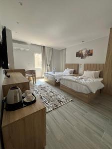 a hotel room with two beds and a television at Saloumy pyramids hotel in Nazlat as Sammān