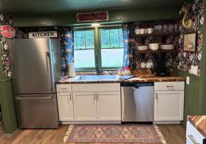 a kitchen with white cabinets and a refrigerator at Kitschy Kottage in Expansion +21 photos
