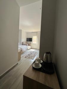 a room with a bed and a table with cups at Saloumy pyramids hotel in Nazlat as Sammān