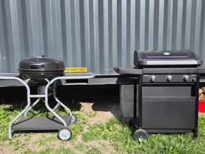 a grill and a bbq cart sitting in the grass at Chalupa Jasanka in Červená Voda